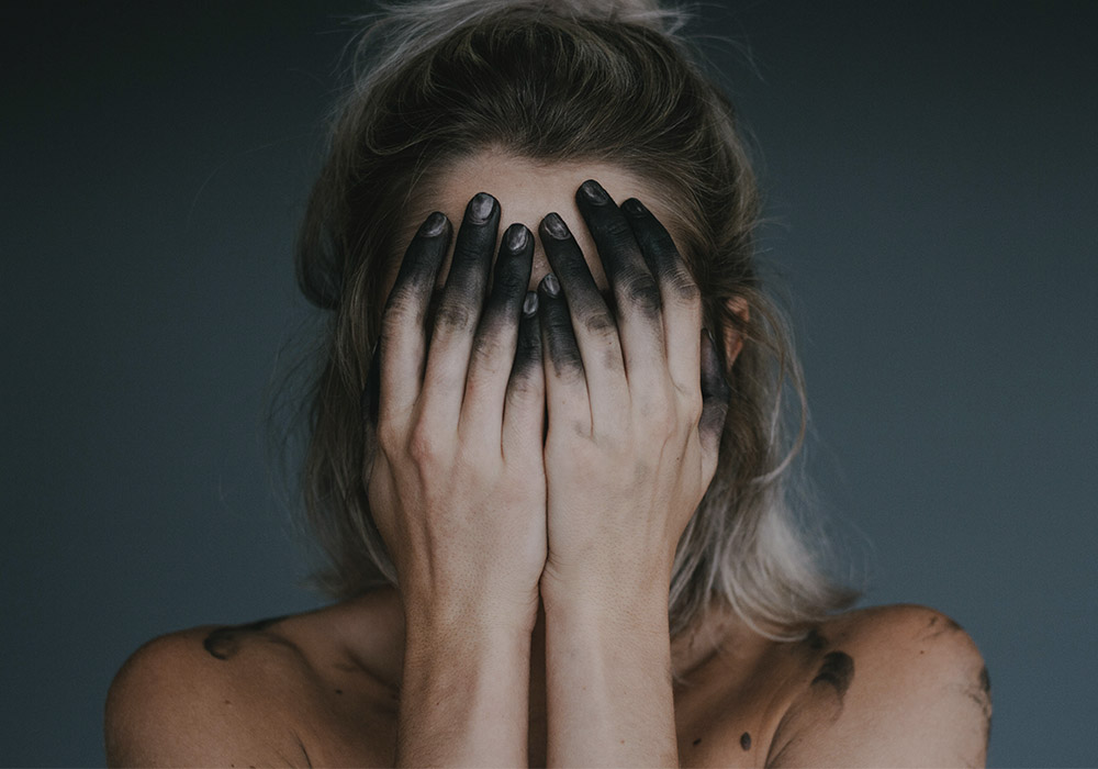 Woman with charcoal powder on hands